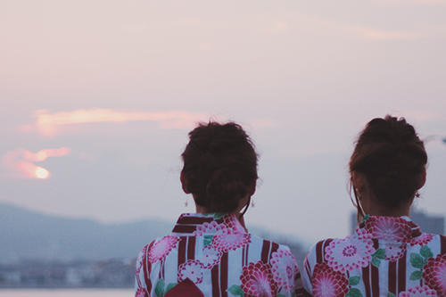 フリー写真画像『浴衣で肩を並べて夕焼けを眺める双子の女の子』[ID:832]