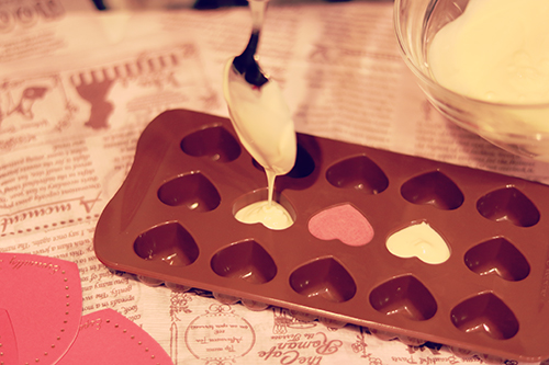 フリー写真画像『バレンタイン用のハートの型にホワイトチョコレートを流し込む様子』[ID:2402]