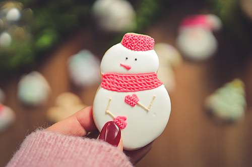 フリー写真画像『雪だるまのアイシングクッキーを持つ女の子の指先』[ID:10671]