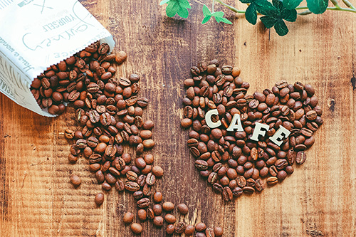 ハート型に並んだコーヒー豆とその上に乗っている Cafe のアルファベットのフリー画像 おしゃれなフリー写真素材 Girly Drop