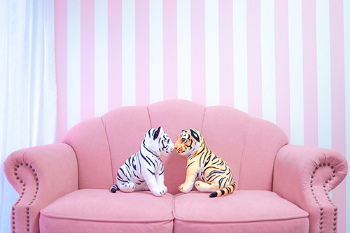 フリー写真画像『ピンクのソファで向かい合う白と黄色の虎のぬいぐるみ』[ID:12750]