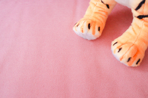 フリー写真画像『ピンクのソファにチラリと映り込む虎のおてて』[ID:12766]