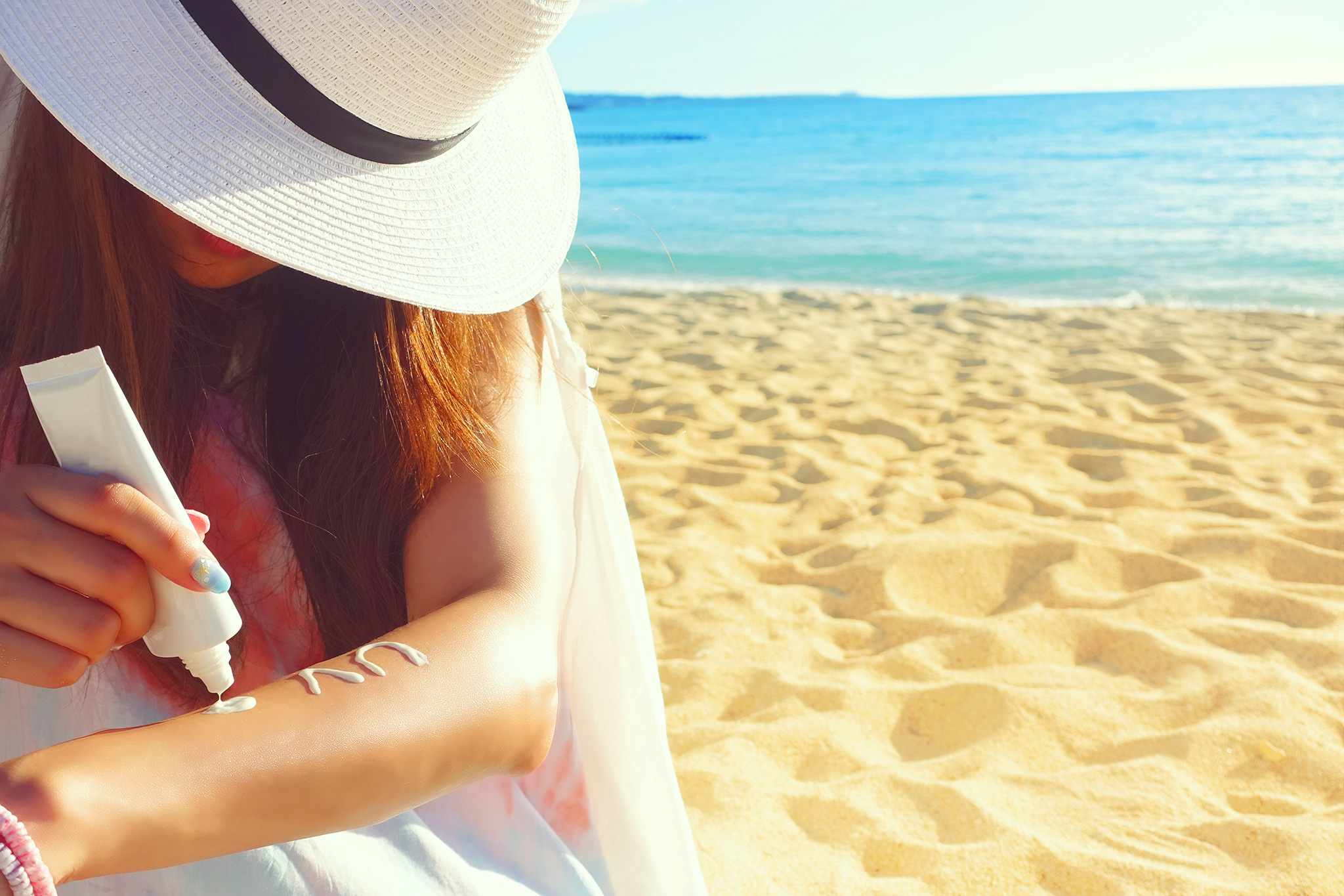 炎天下のビーチで日焼け止めを塗る女の子のフリー画像｜おしゃれなフリー写真素材：GIRLY DROP