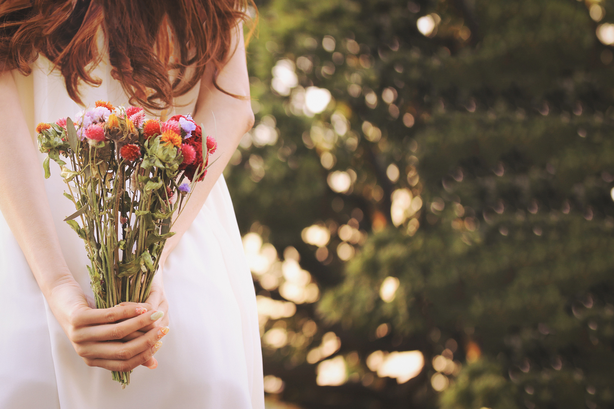 ドライフラワーの花束を背中に隠している女の子のフリー画像｜おしゃれなフリー写真素材：GIRLY DROP