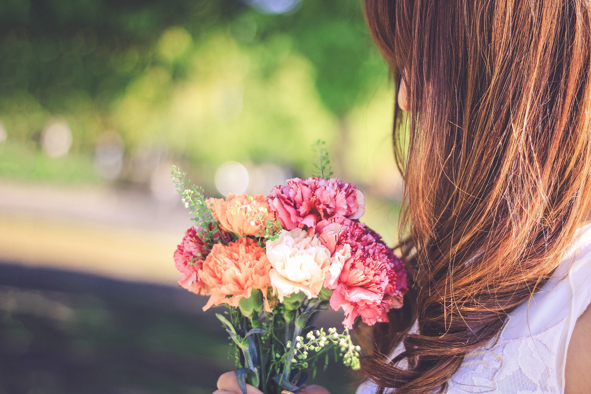よく晴れた春の日にカーネーションの花束を受け取った女の子のフリー画像｜おしゃれなフリー写真素材：GIRLY DROP