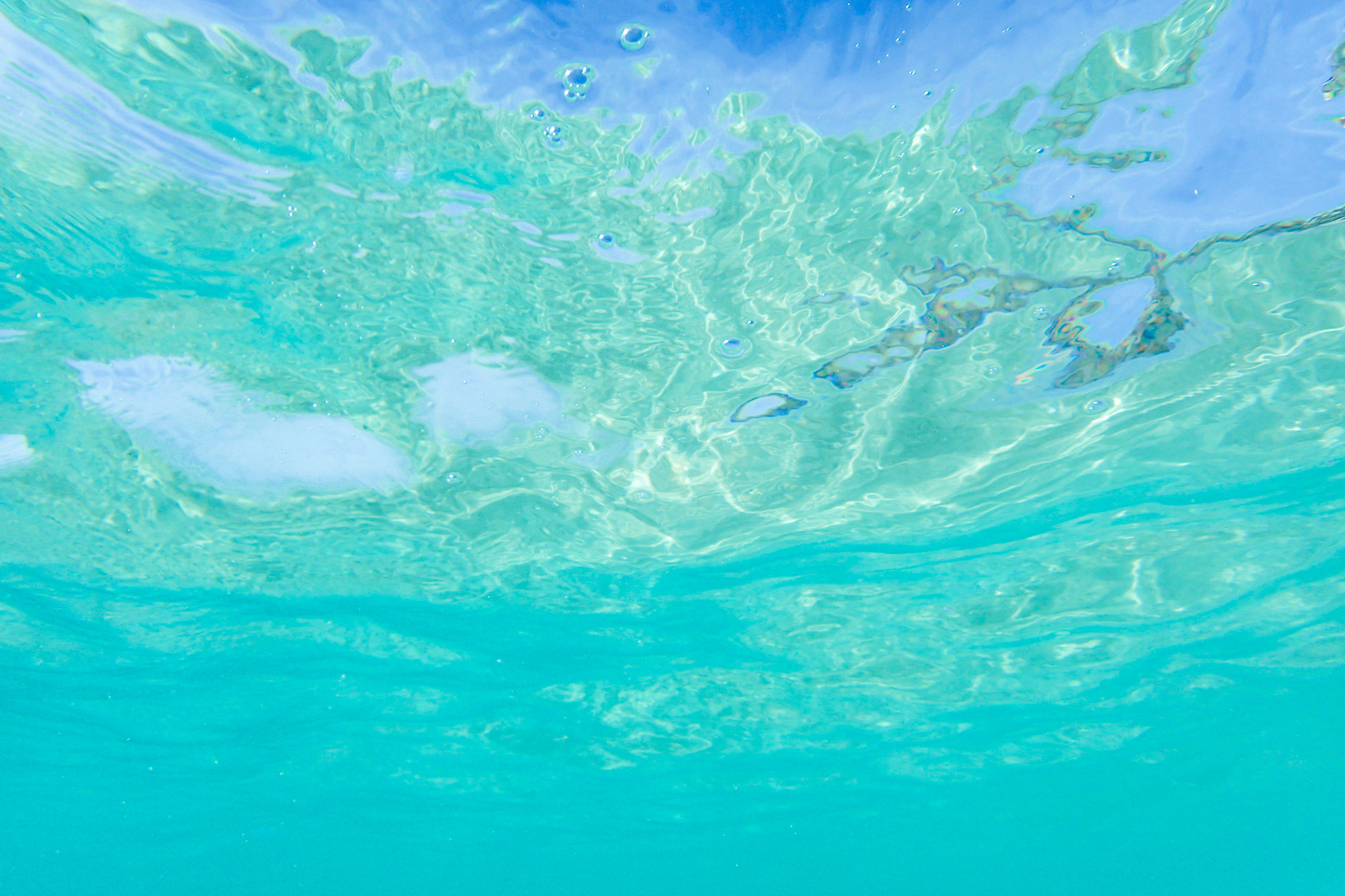 透き通ったエメラルドグリーンの海中から見上げた青い空のフリー画像 おしゃれなフリー写真素材 Girly Drop